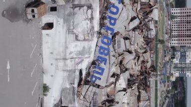 This stock vertical video shows a destroyed building of a shopping center in Bucha during the war in Ukraine, grey, flat video