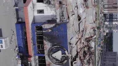 This stock vertical video shows a destroyed building of a shopping center in Bucha during the war in Ukraine, grey, flat video