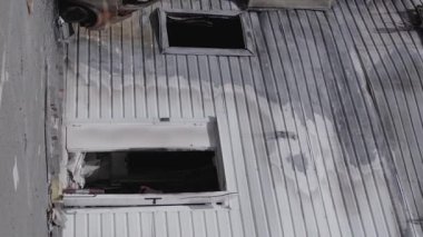 This stock vertical video shows a destroyed building of a shopping center in Bucha during the war in Ukraine, grey, flat video