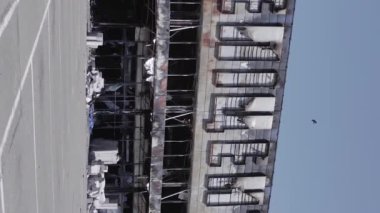This stock vertical video shows a destroyed building of a shopping center in Bucha during the war in Ukraine, grey, flat video