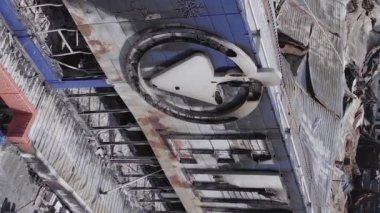 This stock vertical video shows a destroyed building of a shopping center in Bucha during the war in Ukraine, grey, flat video