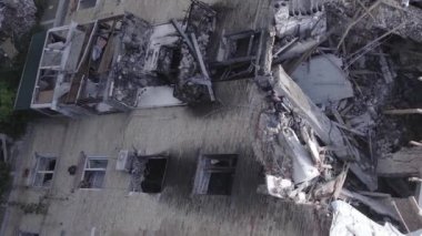 This stock vertical video shows a destroyed building in the city of Makariv during the war in Ukraine, grey, flat video
