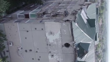 This stock vertical video shows a destroyed building in the city of Makariv during the war in Ukraine, grey, flat video