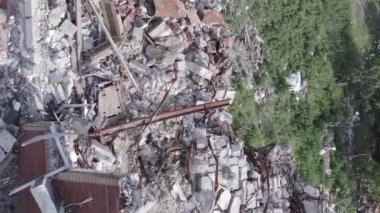 This stock vertical video shows a destroyed building in the city of Makariv during the war in Ukraine, grey, flat video