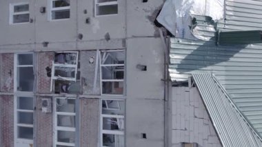 This stock vertical video shows a destroyed building in the city of Makariv during the war in Ukraine, grey, flat video