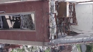 This stock vertical video shows a destroyed building in the city of Makariv during the war in Ukraine, grey, flat video
