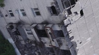 This stock vertical video shows a destroyed building in the city of Makariv during the war in Ukraine, grey, flat video