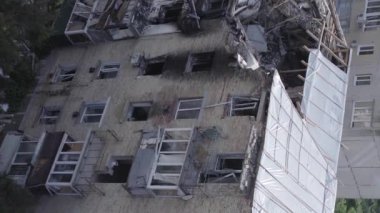 This stock vertical video shows a destroyed building in the city of Makariv during the war in Ukraine, grey, flat video