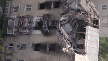 This stock vertical video shows a destroyed building in the city of Makariv during the war in Ukraine, grey, flat video