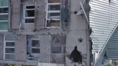 This stock vertical video shows a destroyed building in the city of Makariv during the war in Ukraine, grey, flat video
