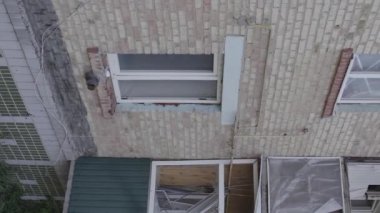 This stock vertical video shows a destroyed building in the city of Makariv during the war in Ukraine, grey, flat video