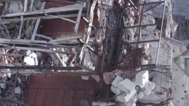 This stock vertical video shows a destroyed building in the city of Makariv during the war in Ukraine, grey, flat video