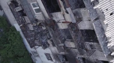This stock vertical video shows a destroyed building in the city of Makariv during the war in Ukraine, grey, flat video