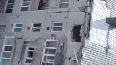 This stock vertical video shows a destroyed building in the city of Makariv during the war in Ukraine, grey, flat video
