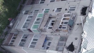 This stock vertical video shows a destroyed building in the city of Makariv during the war in Ukraine, grey, flat video