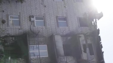 This stock vertical video shows a destroyed building in the city of Makariv during the war in Ukraine, grey, flat video