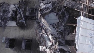 This stock vertical video shows a destroyed building in the city of Makariv during the war in Ukraine, grey, flat video