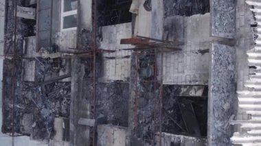 This stock vertical video shows a destroyed building in the city of Makariv during the war in Ukraine, grey, flat video