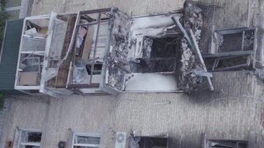 This stock vertical video shows a destroyed building in the city of Makariv during the war in Ukraine, grey, flat video