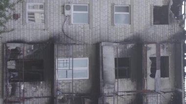 This stock vertical video shows a destroyed building in the city of Makariv during the war in Ukraine, grey, flat video
