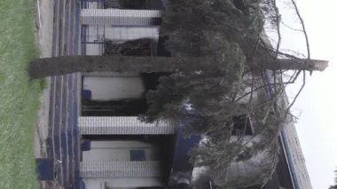 This stock vertical video shows the aftermath of the war in Ukraine - the destroyed and burned building of the police station in Borodyanka, Kyiv region, grey, flat video