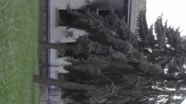 This stock vertical video shows the aftermath of the war in Ukraine - the destroyed and burned building of the police station in Borodyanka, Kyiv region, grey, flat video