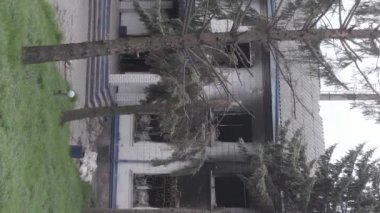 This stock vertical video shows the aftermath of the war in Ukraine - the destroyed and burned building of the police station in Borodyanka, Kyiv region, grey, flat video