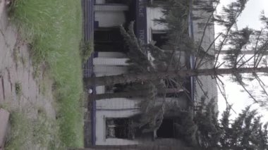 This stock vertical video shows the aftermath of the war in Ukraine - the destroyed and burned building of the police station in Borodyanka, Kyiv region, grey, flat video
