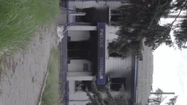 This stock vertical video shows the aftermath of the war in Ukraine - the destroyed and burned building of the police station in Borodyanka, Kyiv region, grey, flat video