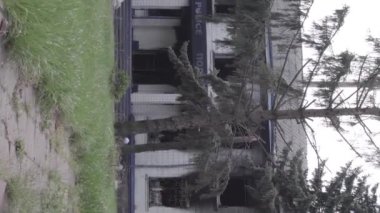 This stock vertical video shows the aftermath of the war in Ukraine - the destroyed and burned building of the police station in Borodyanka, Kyiv region, grey, flat video