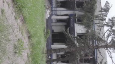 This stock vertical video shows the aftermath of the war in Ukraine - the destroyed and burned building of the police station in Borodyanka, Kyiv region, grey, flat video