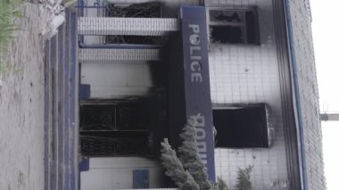 This stock vertical video shows the aftermath of the war in Ukraine - the destroyed and burned building of the police station in Borodyanka, Kyiv region, grey, flat video