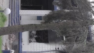 This stock vertical video shows the aftermath of the war in Ukraine - the destroyed and burned building of the police station in Borodyanka, Kyiv region, grey, flat video