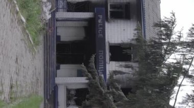 This stock vertical video shows the aftermath of the war in Ukraine - the destroyed and burned building of the police station in Borodyanka, Kyiv region, grey, flat video