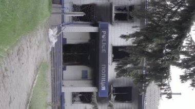 This stock vertical video shows the aftermath of the war in Ukraine - the destroyed and burned building of the police station in Borodyanka, Kyiv region, grey, flat video