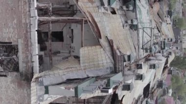 This stock vertical video shows a war-torn building in Stoyanka, Bucha district, Ukraine, flat, grey video