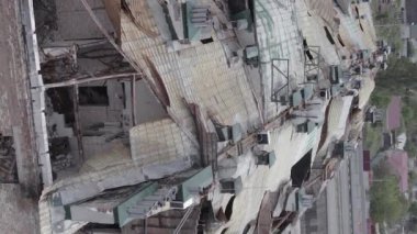 This stock vertical video shows a war-torn building in Stoyanka, Bucha district, Ukraine, flat, grey video