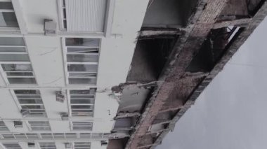 This stock vertical video shows a war-torn building in Stoyanka, Bucha district, Ukraine, flat, grey video