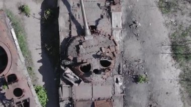 This stock vertical video shows an aerial view of destroyed military equipment in Ukraine, flat, grey video