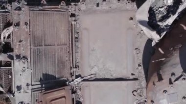 This stock vertical video shows an aerial view of destroyed military equipment in Ukraine, flat, grey video