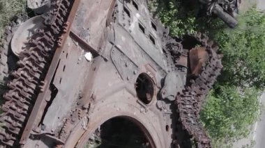 This stock vertical video shows an aerial view of destroyed military equipment in Ukraine, flat, grey video