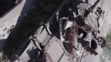 This stock vertical video shows an aerial view of destroyed military equipment in Ukraine, flat, grey video