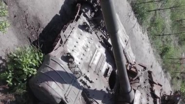 This stock vertical video shows an aerial view of destroyed military equipment in Ukraine, flat, grey video