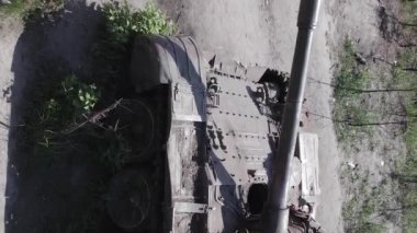 This stock vertical video shows an aerial view of destroyed military equipment in Ukraine, flat, grey video