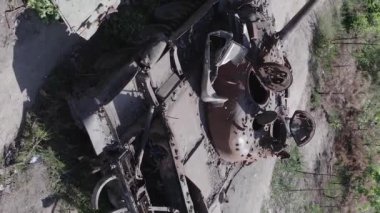 This stock vertical video shows an aerial view of destroyed military equipment in Ukraine, flat, grey video