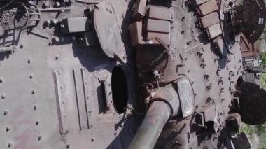 This stock vertical video shows an aerial view of destroyed military equipment in Ukraine, flat, grey video