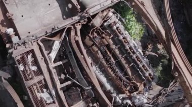 This stock vertical video shows an aerial view of destroyed military equipment in Ukraine, flat, grey video