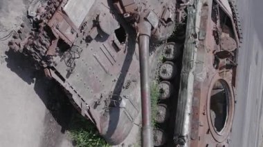 This stock vertical video shows an aerial view of destroyed military equipment in Ukraine, flat, grey video