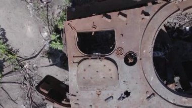 This stock vertical video shows an aerial view of destroyed military equipment in Ukraine, flat, grey video