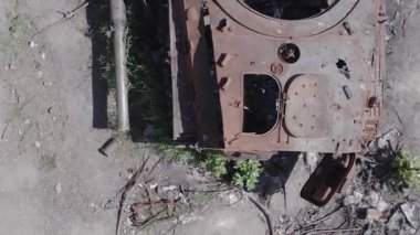 This stock vertical video shows an aerial view of destroyed military equipment in Ukraine, flat, grey video